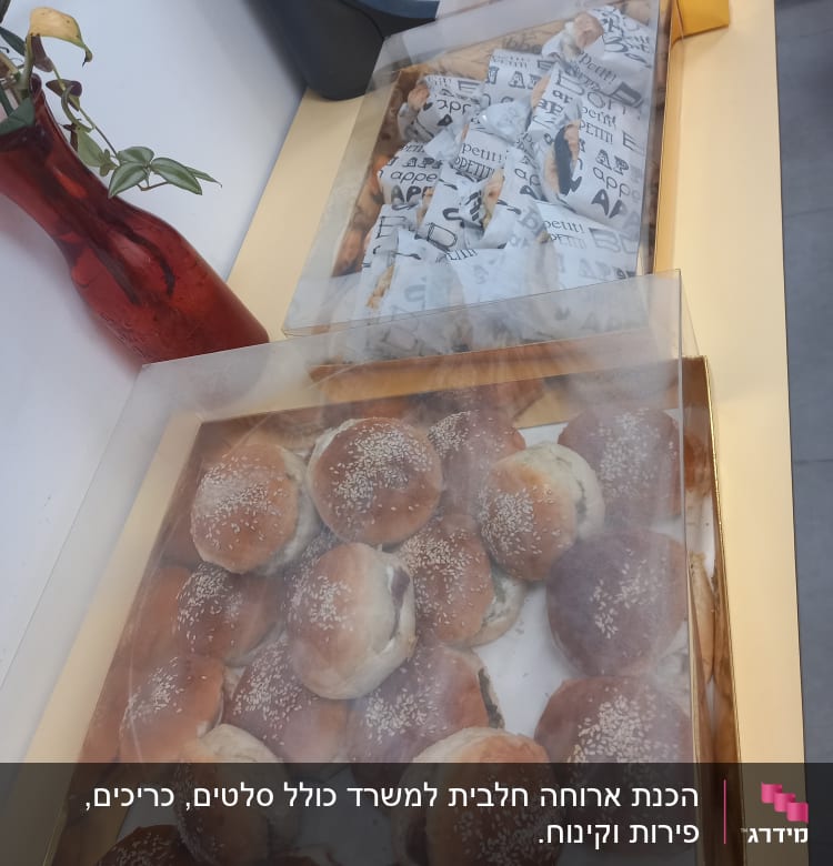 מגש לחמניות שומשום ועטיפות נייר על שולחן קייטרינג